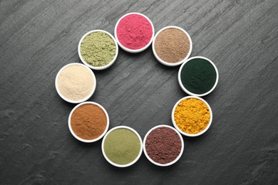 Photo of Different superfood powders on black table, flat lay