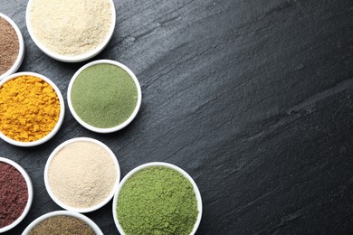 Photo of Different superfood powders on black table, flat lay. Space for text