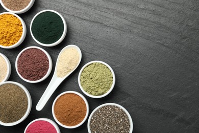 Photo of Different superfood powders on black table, flat lay. Space for text