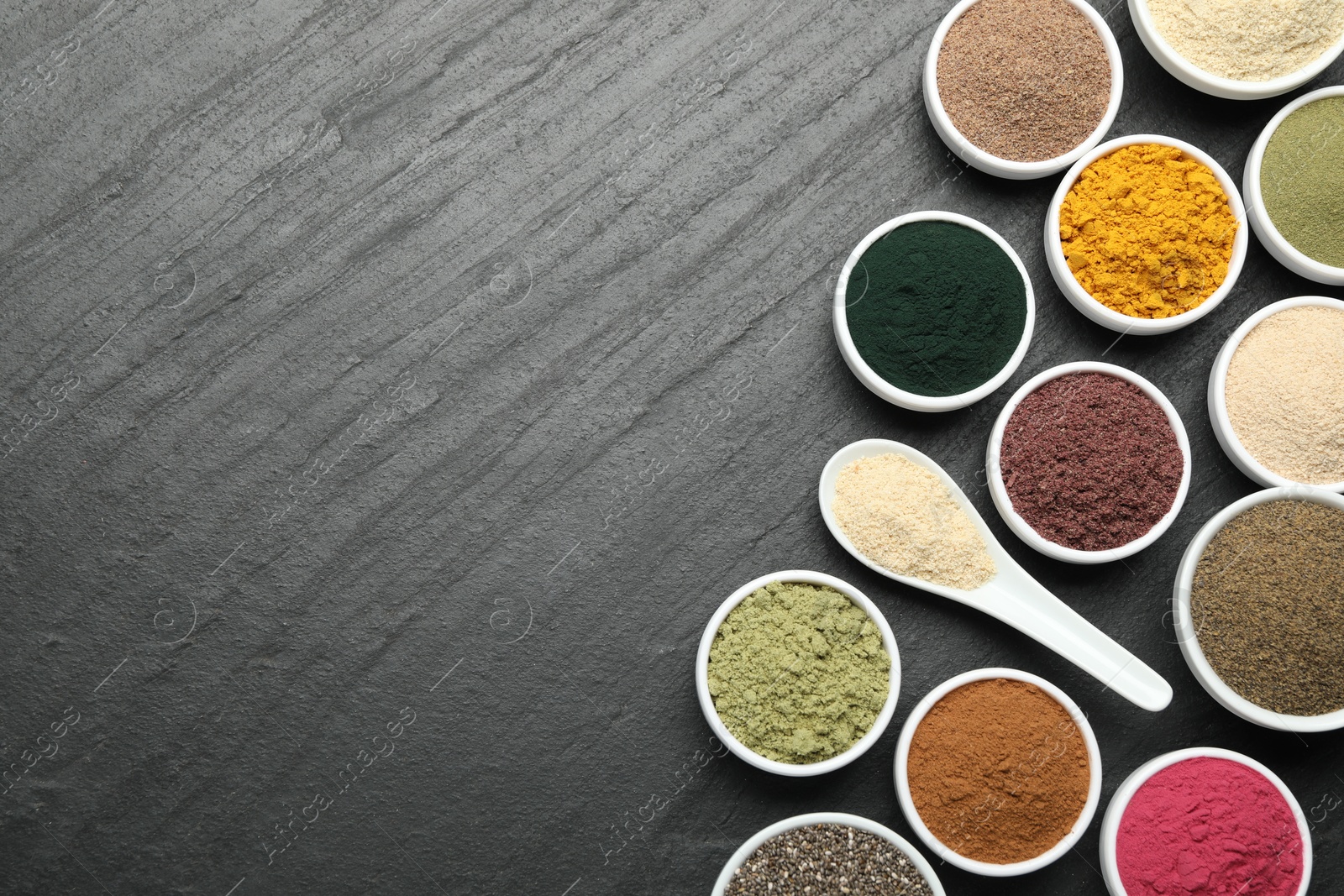 Different superfood powders on black table, flat lay. Space for text Photo of Different superfood powders on black table, flat lay. Space for text