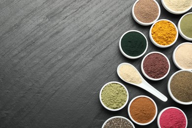 Photo of Different superfood powders on black table, flat lay. Space for text