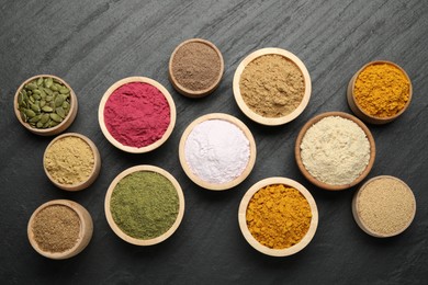 Photo of Different superfood powders on black table, flat lay