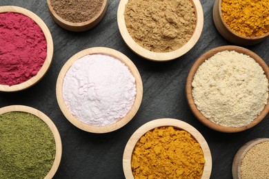Photo of Different superfood powders on black table, flat lay