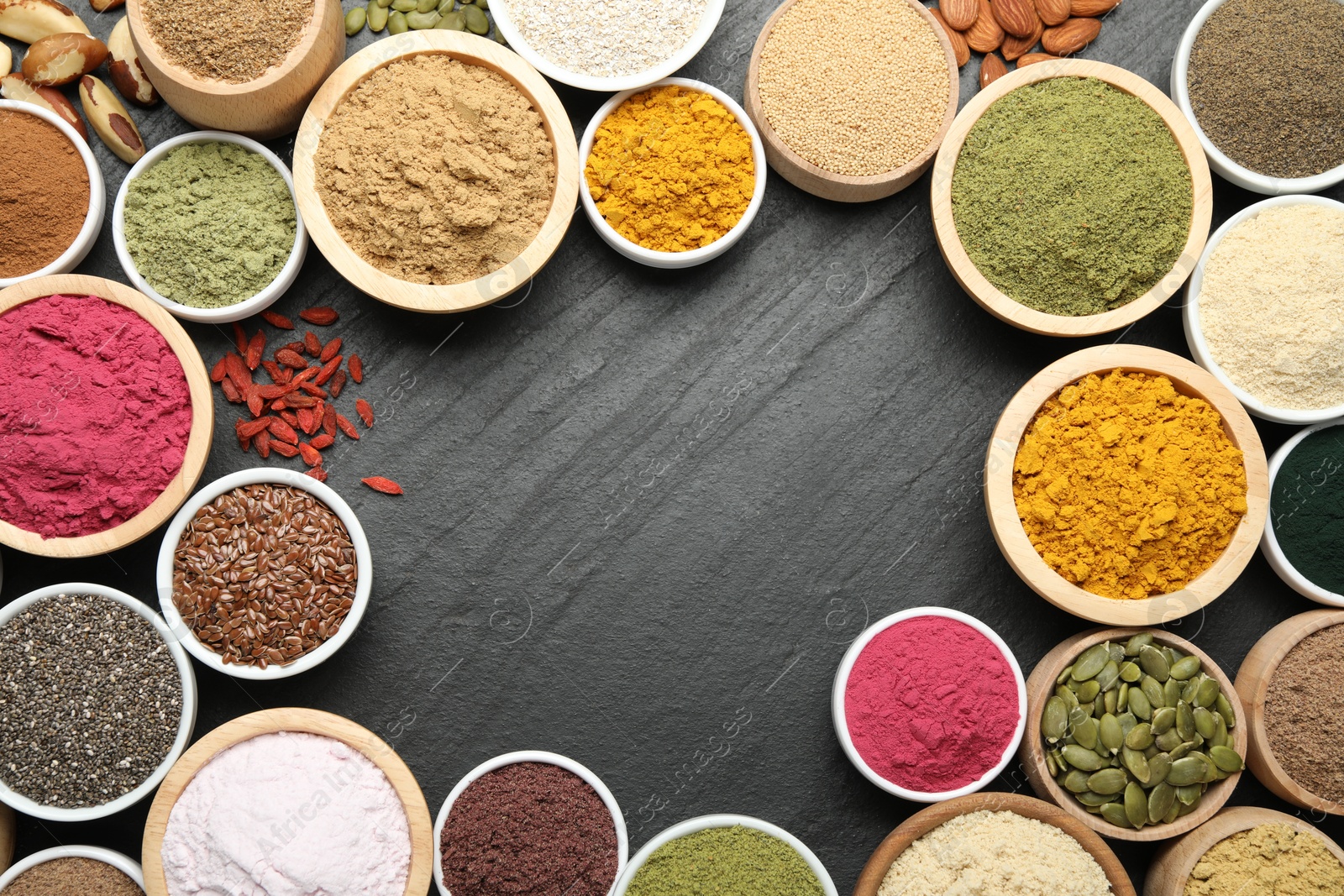Photo of Frame of different superfood powders on black table, flat lay. Space for text