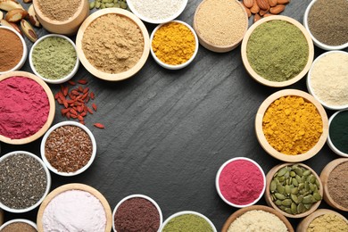 Photo of Frame of different superfood powders on black table, flat lay. Space for text
