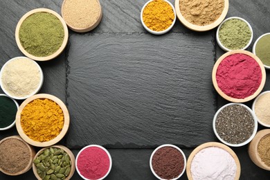 Photo of Frame of different superfood powders on black table, flat lay. Space for text
