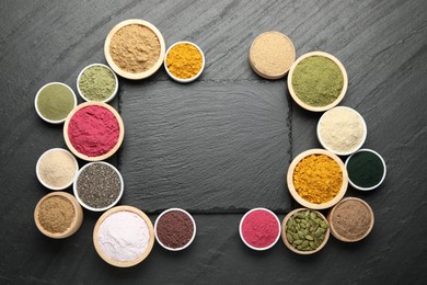 Photo of Frame of different superfood powders on black table, flat lay. Space for text