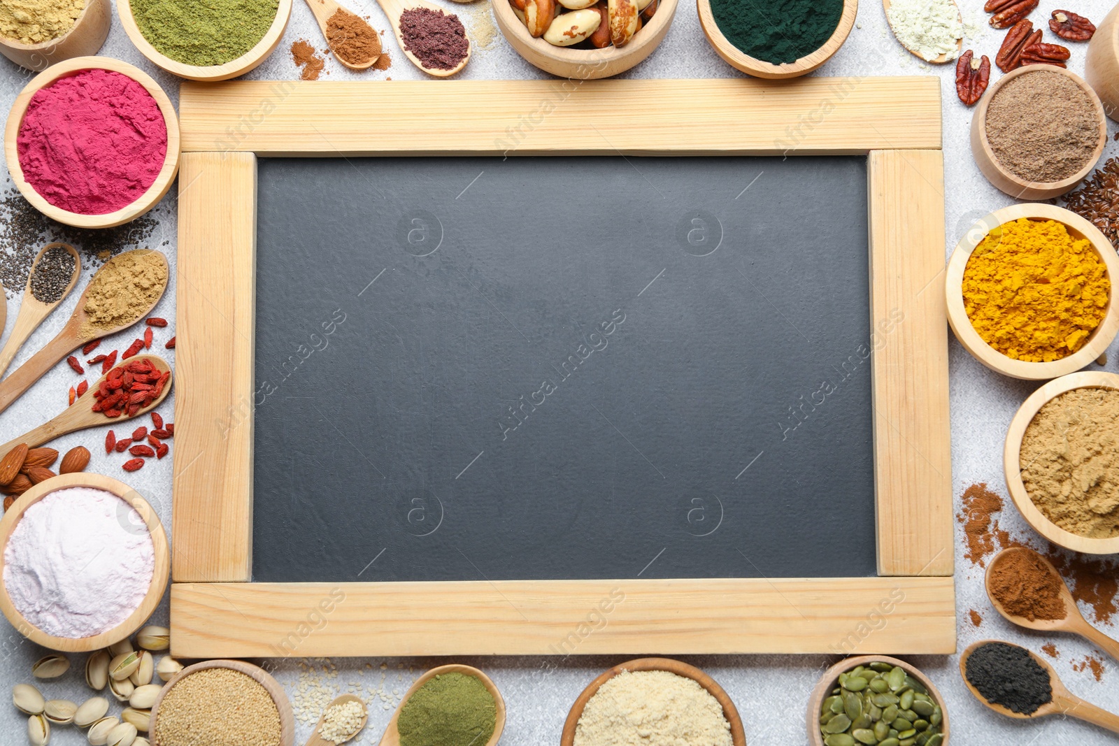 Different superfood powders and chalkboard on light grey table, flat lay. Space for text Photo of Different superfood powders and chalkboard on light grey table, flat lay. Space for text