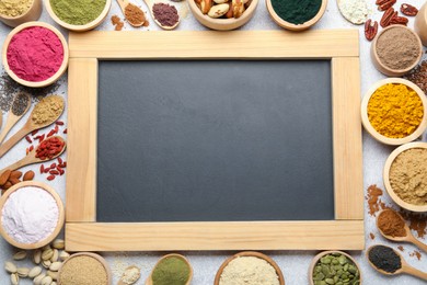 Photo of Different superfood powders and chalkboard on light grey table, flat lay. Space for text