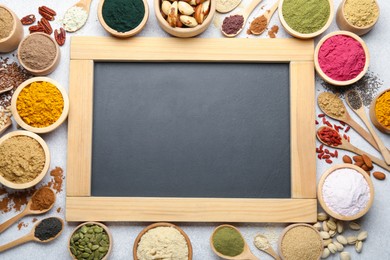 Photo of Different superfood powders and chalkboard on light grey table, flat lay. Space for text