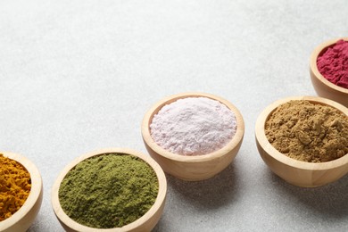 Photo of Different superfood powders on light grey table, closeup. Space for text