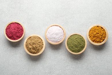 Photo of Different superfood powders on light grey table, flat lay