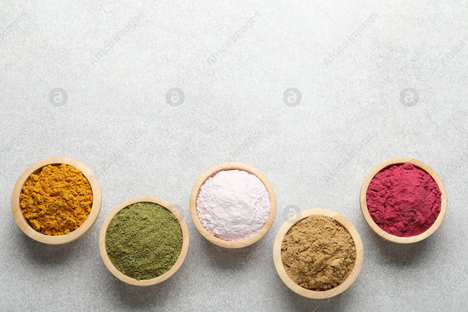 Different superfood powders on light grey table, flat lay. Space for text Photo of Different superfood powders on light grey table, flat lay. Space for text