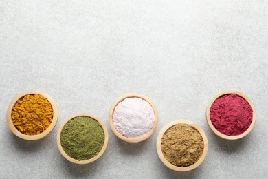 Photo of Different superfood powders on light grey table, flat lay. Space for text