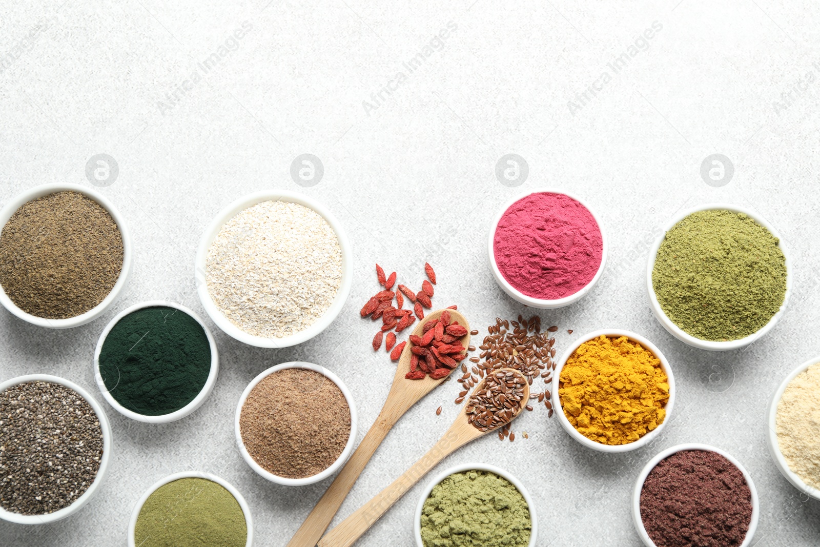 Different superfood powders on light grey table, flat lay. Space for text Photo of Different superfood powders on light grey table, flat lay. Space for text
