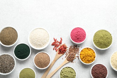 Photo of Different superfood powders on light grey table, flat lay. Space for text