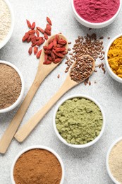 Photo of Different superfood powders on light grey table, flat lay