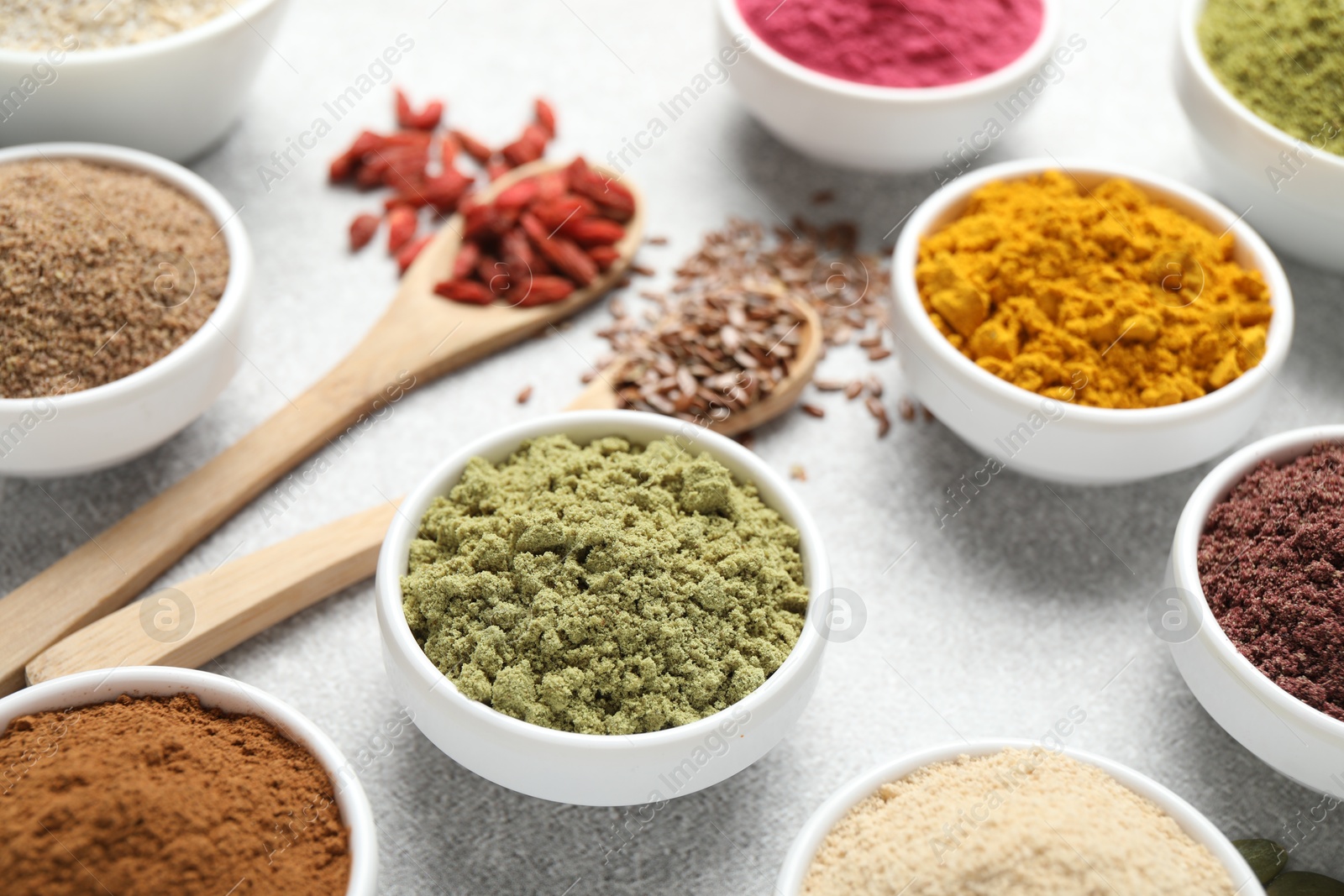 Different superfood powders on light grey table, closeup Photo of Different superfood powders on light grey table, closeup