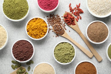 Photo of Different superfood powders on light grey table, flat lay