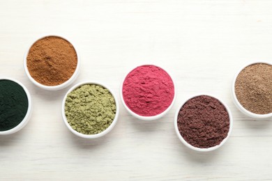 Photo of Different superfood powders on white wooden table, flat lay