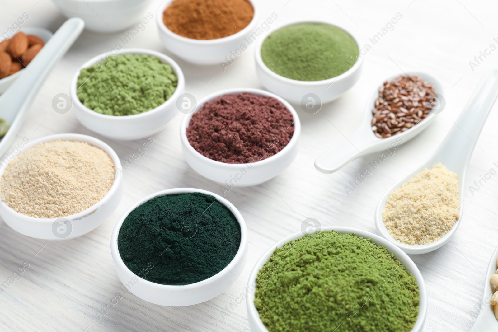 Different superfood powders on white wooden table, closeup Photo of Different superfood powders on white wooden table, closeup