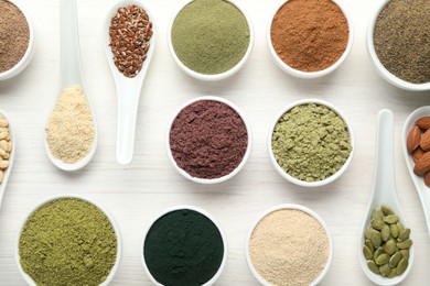 Photo of Different superfood powders on white wooden table, flat lay