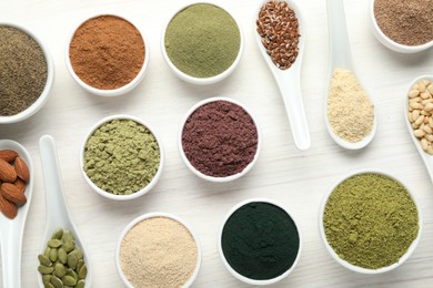 Photo of Different superfood powders on white wooden table, flat lay