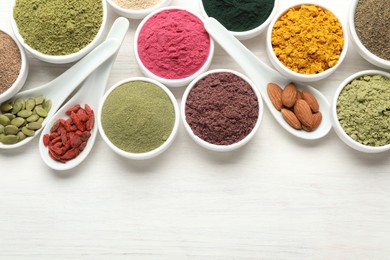 Photo of Different superfood powders on white wooden table, flat lay. Space for text