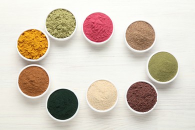 Photo of Frame of different superfood powders on white wooden table, flat lay. Space for text