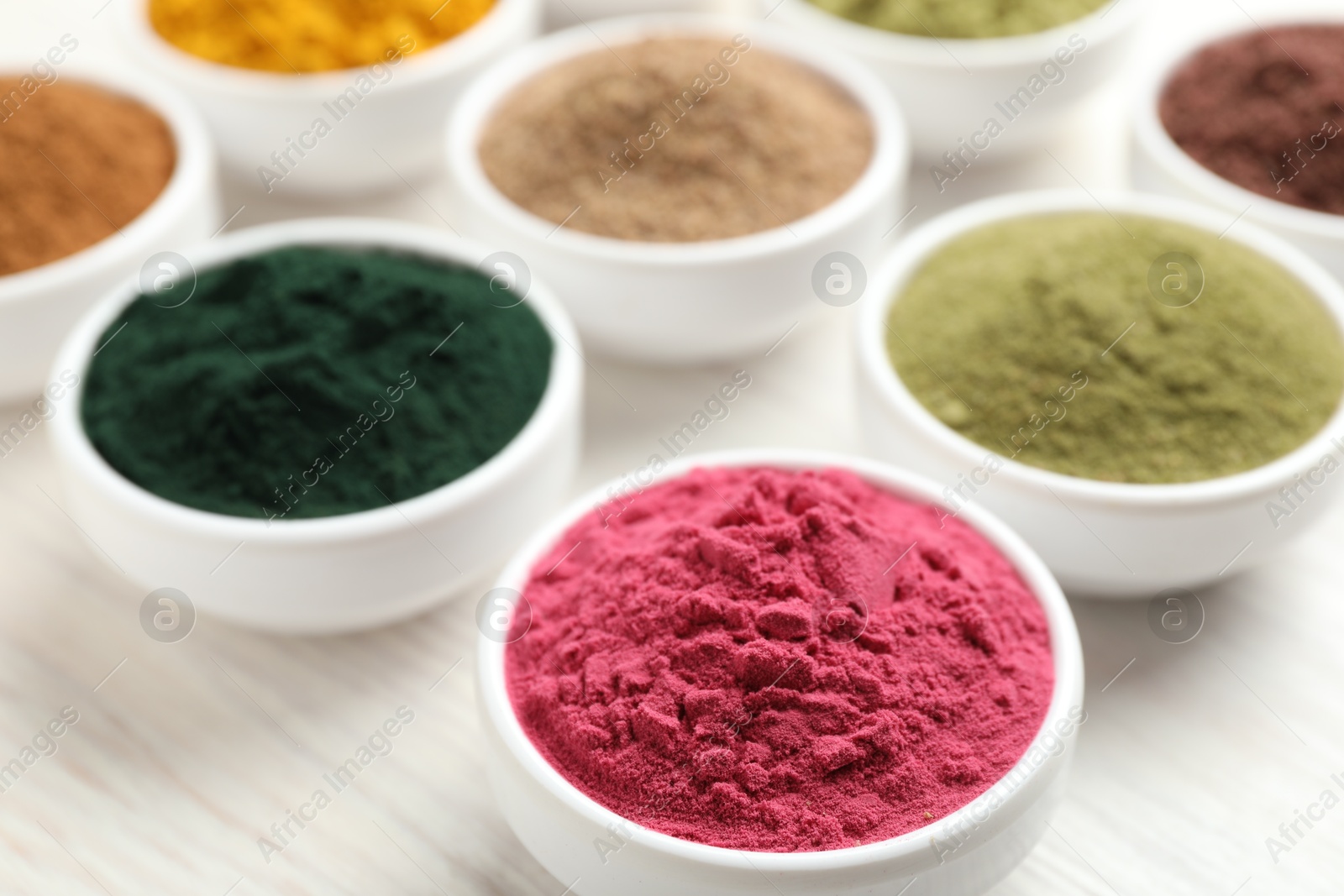 Different superfood powders on white wooden table, closeup Photo of Different superfood powders on white wooden table, closeup