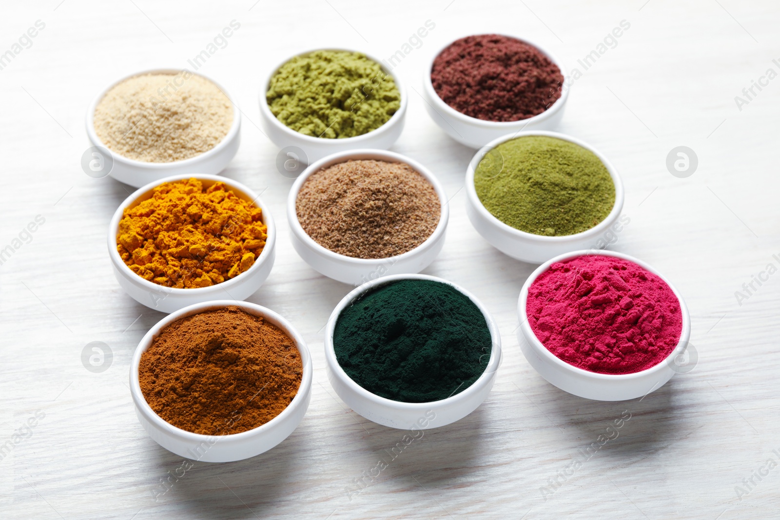 Different superfood powders on white wooden table, closeup Photo of Different superfood powders on white wooden table, closeup