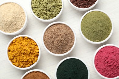 Photo of Different superfood powders on white wooden table, flat lay