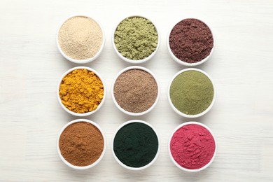 Photo of Different superfood powders on white wooden table, flat lay