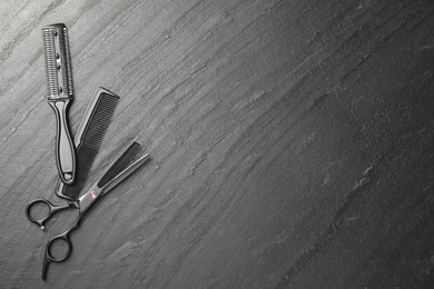 Photo of Different barber's tools on black table, flat lay. Space for text
