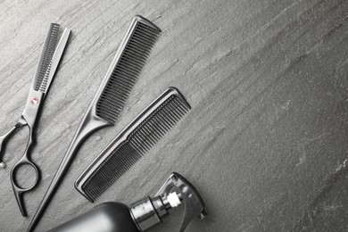 Photo of Different barber's tools on black table, flat lay. Space for text