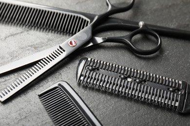 Photo of Different barber's tools on black table, closeup