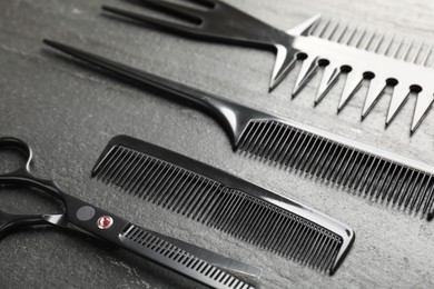 Photo of Different barber's tools on black table, closeup
