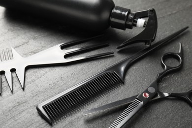 Photo of Different barber's tools on black table, closeup