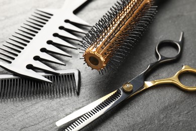 Photo of Different barber's tools on black table, closeup