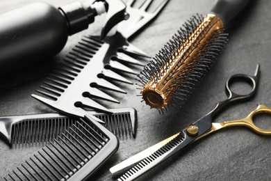 Photo of Different barber's tools on black table, closeup