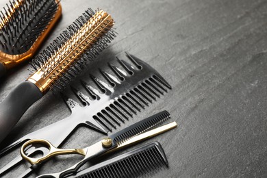 Photo of Different barber's tools on black table, closeup. Space for text
