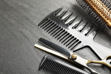 Photo of Different barber's tools on black table, closeup. Space for text