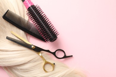 Photo of Hair strand and hairdresser's tools on light pink background, flat lay. Space for text