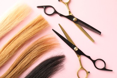 Photo of Hair strands and hairdresser's tools on light pink background, flat lay