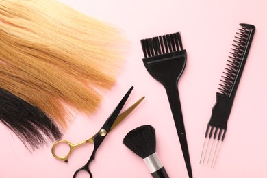 Photo of Hair strand and hairdresser's tools on light pink background, flat lay
