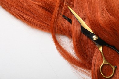 Photo of Hair strand and scissors on light background, top view. Space for text