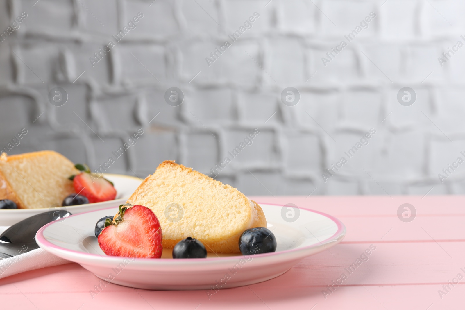 Pieces of tasty bundt cake with berries on pink wooden table, closeup. Space for text Photo of Pieces of tasty bundt cake with berries on pink wooden table, closeup. Space for text