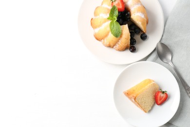 Photo of Tasty bundt cake with powdered sugar, berries, mint and spoon on white table, flat lay. Space for text