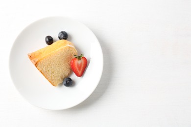 Photo of Pieces of tasty bundt cake with berries on white background, top view. Space for text