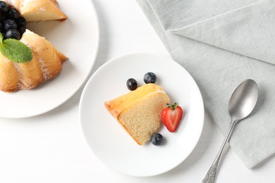 Photo of Tasty bundt cake with powdered sugar, berries and mint on white table, flat lay